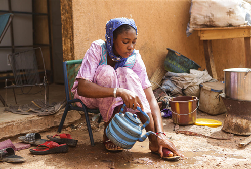 Kadidia*, aged 14, washes her feet outside her home in Mopti region, Mali. 