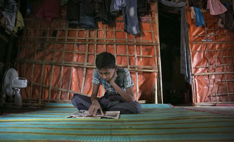 Tomal reads newspapers at his shelter