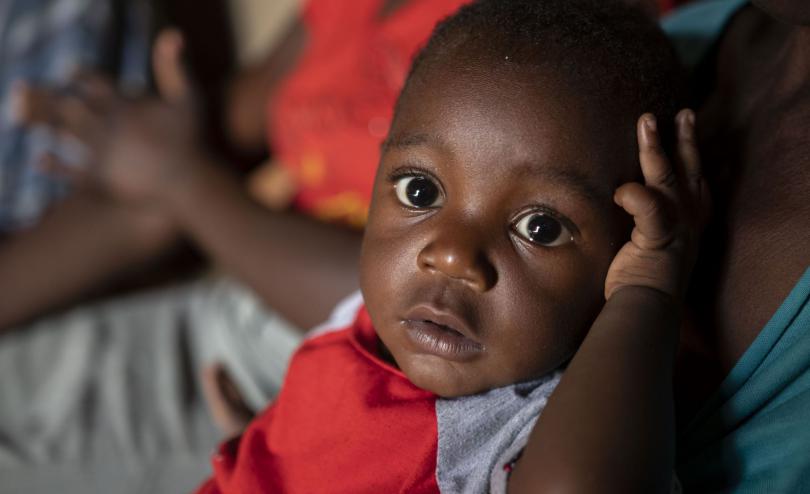 A young child looks into the camera