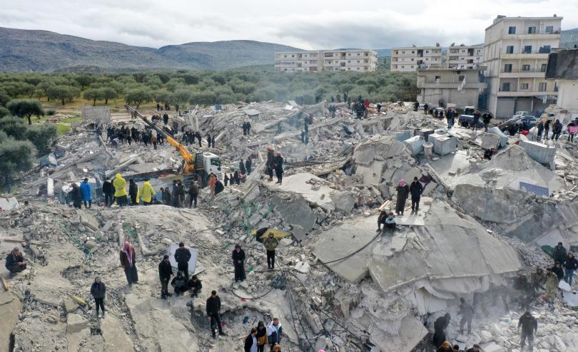 aerial view shows residents searching for victims and survivors amidst the rubble of collapsed buildings following an earthquake