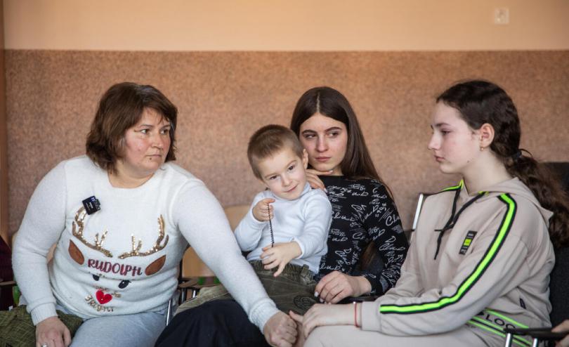 Halyna* comforts her niece Olha*, 10, who recalls living close to the frontline, while Halyna's daughter Polina*, holds her brother (OLEKSANDR KHOMENKO/ Save the Children)