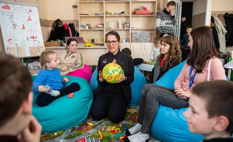 SCI CEO Inger Ashing holds a ball and plays with children in a Child Friendly Space in Kyiv region, Ukraine.