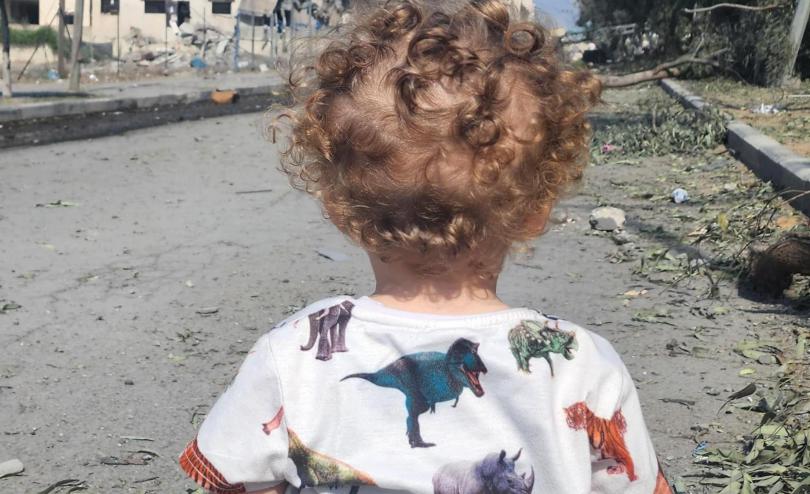 2-year-old Omar look out at destroyed street in Gaza. 