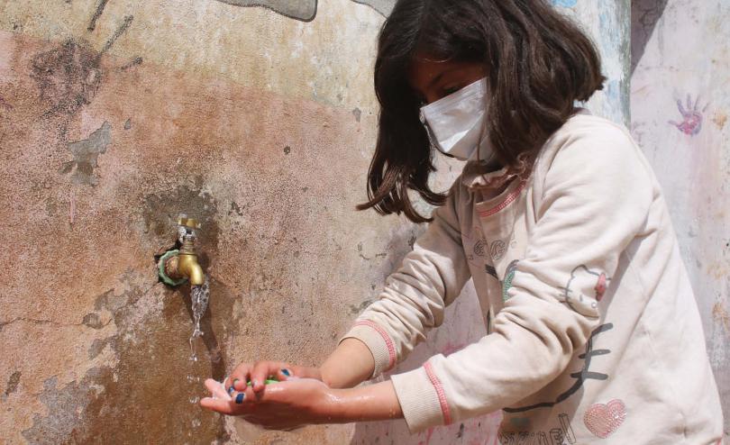 Tala*, 9 washing her hands in a camp in northern Idlib in Syria