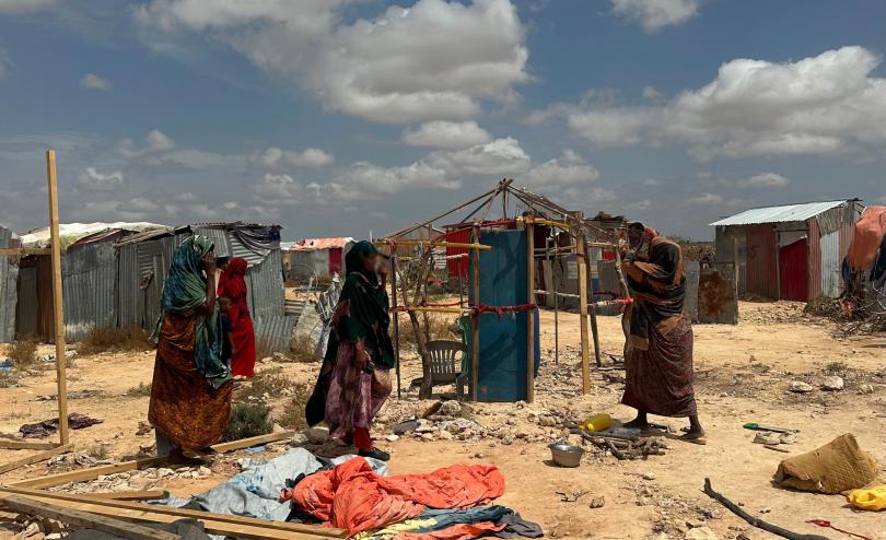 Women building a shelter at displacement camp in Somalia