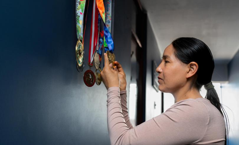 Olympian Inés Melchor, Peru, long-distance runner, looks at her medals.