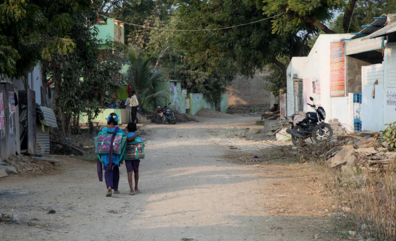 Sandhya, 13, and her brother Shivaji, 8, walk home from their school which has Save the Children supported beautified classrooms with teaching and learning materials