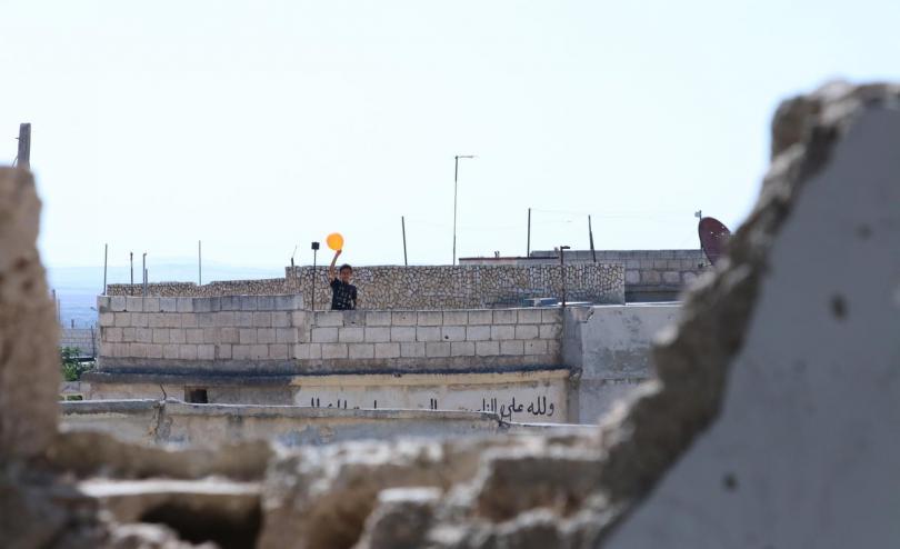 A boy seen through rubble near the school, Idlib Syria