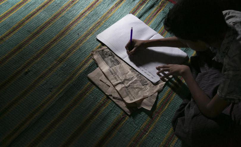 Tomal * writing at his shelter in Cox's Bazar