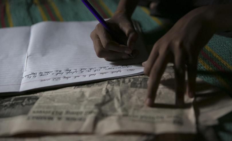  Tomal * writing at his shelter in Cox's Bazar