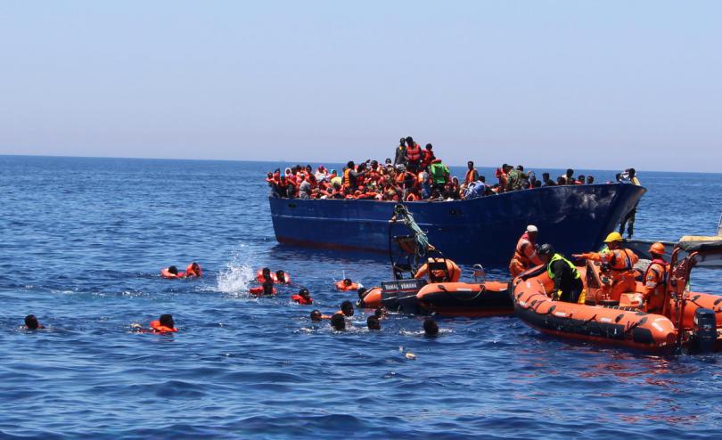 Terrifying moment when desperate refugees and migrants fall in the water from an overcrowded wooden boat in the central Med 2017