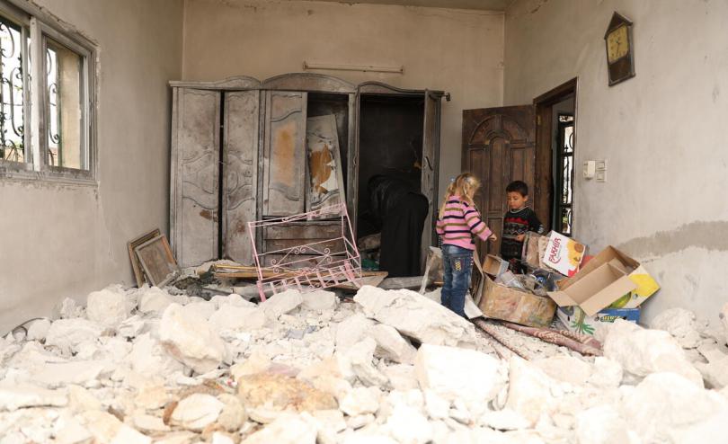 Ayman* with his grandchildren in their damaged home Syria