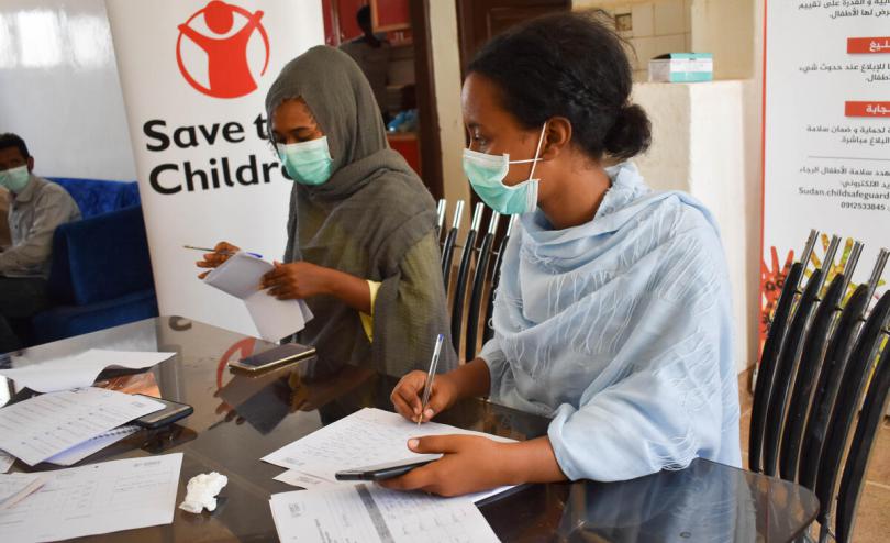 Two of Save the Children's volunteers are registering immigrants and refugees names for cash distribution.