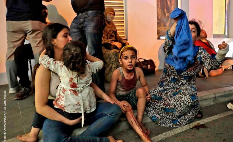 Wounded people wait to received help outside a hospital following an explosion in the Lebanese capital Beirut on August 4, 2020
