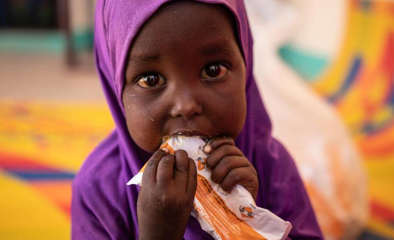 Salma (2) eats therapeutic food used to treat children with malnutrition at a Save the Children clinic in Somalia