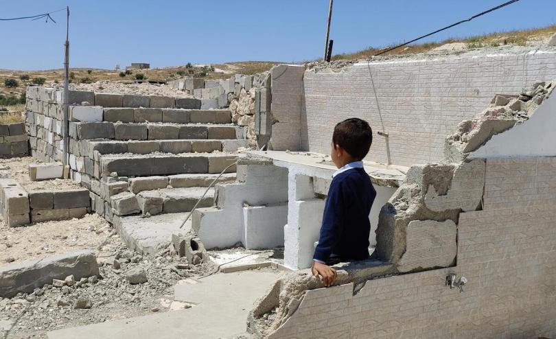 Lee*, 6 looking at the rubble after his home was demolished in South Hebron, West Bank