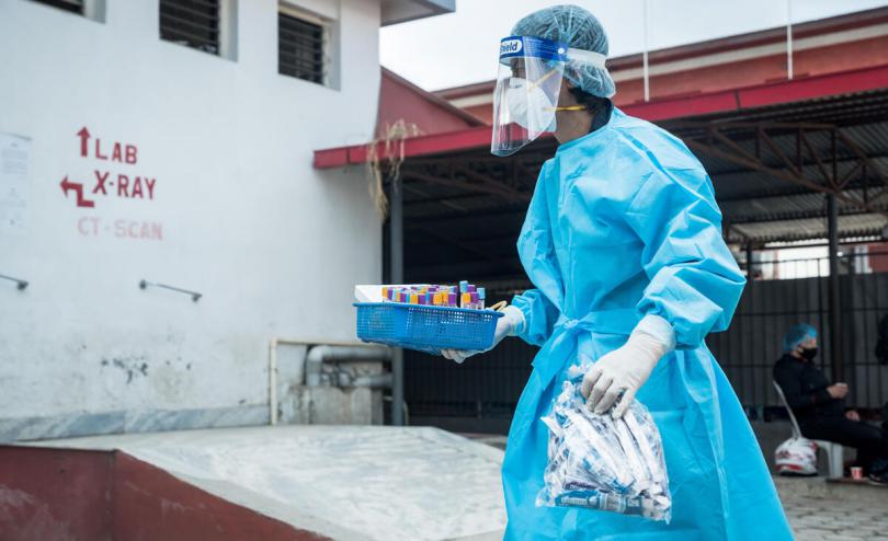 Health worker carries COVID-19 test samples, Nepal, May 2021