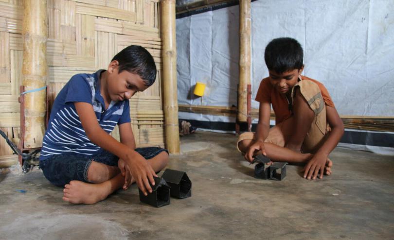  Banna*, 11, playing with his brother Arif*, 10, at their home in Cox's Bazar, Bangladesh