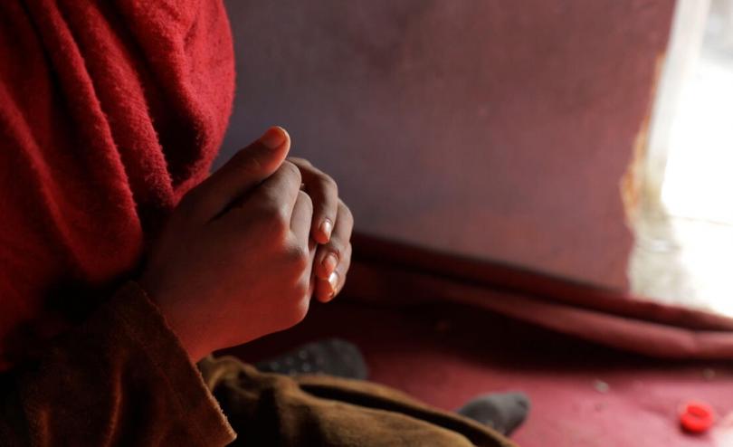 Afghan child sitting and speaking to another person