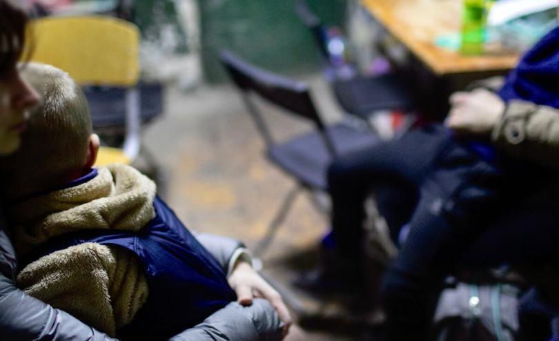 A mother comforts her five year old son as they shelter inside a school in Kyiv, Ukraine with many other