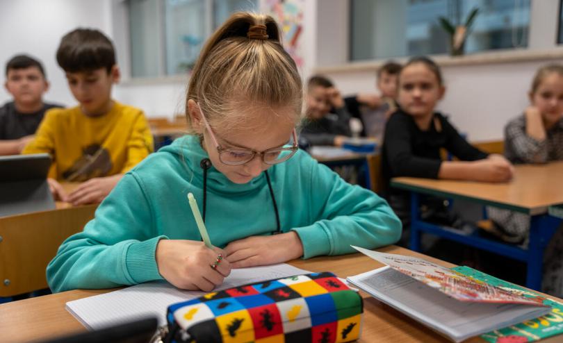 girl sits at her school desk in Poland