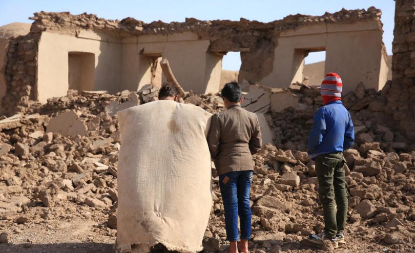 Children in Afghanistan look at rubble following earthquake