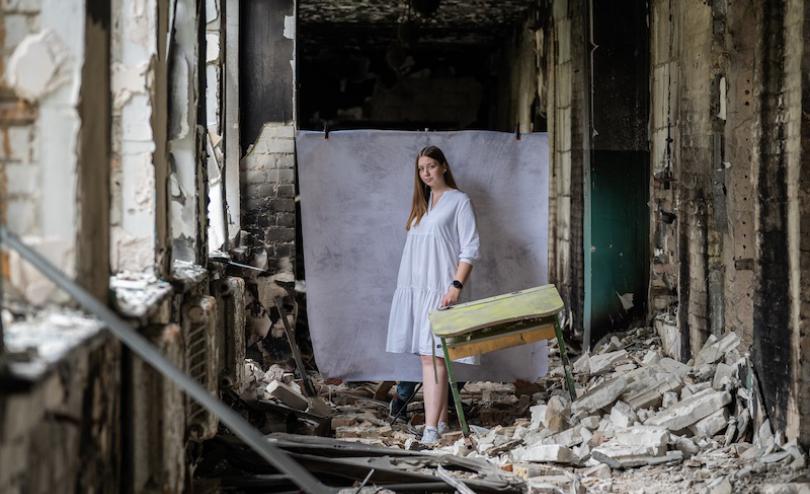Olena*, 17, poses for a portrait at her damaged school outside of Kyiv (Oleksandr Khomenko/Save the Children)