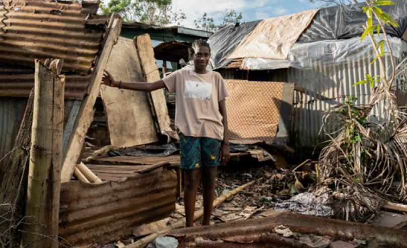 A child stands amid rubble caused by a cyclone in March 2023