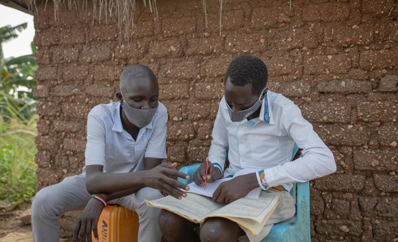 Two children reading with face masks on