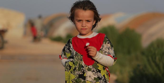 Abeer,6, standing outside her family's tend in Syria