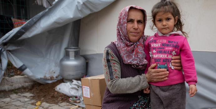Eylül* and granddaughter Fatima*, 3, outside her tent in the Adiyaman region, Türkiye.