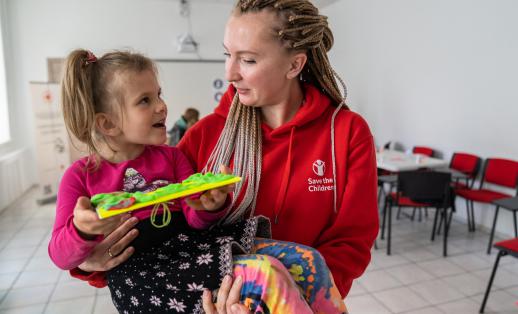 Olga Shults, Save the Children's programme manager, is holding a girl at Child Friendly Space in Mykolaiv, Ukraine