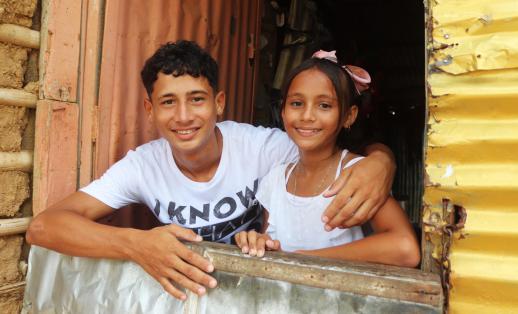 Sebastian, 16, with his sister Joana, 11, in their home in Colombia