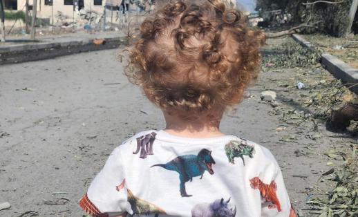 2-year-old Omar look out at destroyed street in Gaza. 