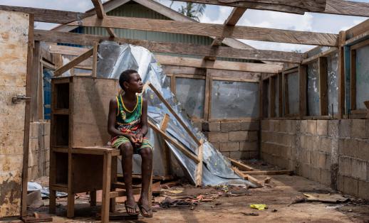 an 11 year old boy sits in his damaged school