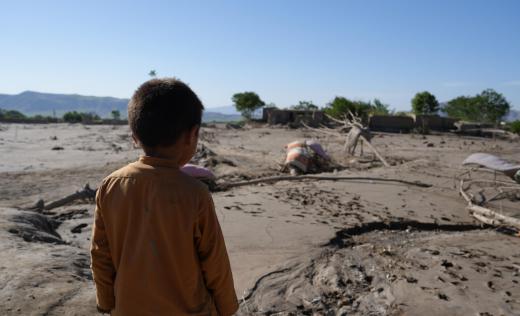 A child watching the village destroyed by recent floods