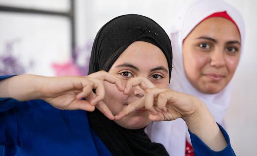 Alva, 13, makes a heart sign at a Girls Empowerment Centre in Zaatari Refugee Camp, Jordan