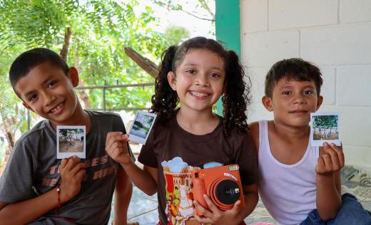 Edgar, 8, Diana*, 8, & Leonardo, 7, showing the photos of their favorite places or activities