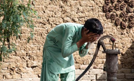 A 13 year old boy keeps cool in scorching heat in Pakistan