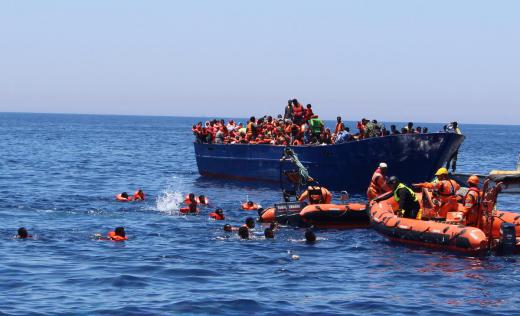 Terrifying moment when desperate refugees and migrants fall in the water from an overcrowded wooden boat in the central Med 2017