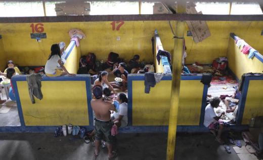 Families eating and resting at Bauan Cockpit Arena which now serves as an evacuation centre