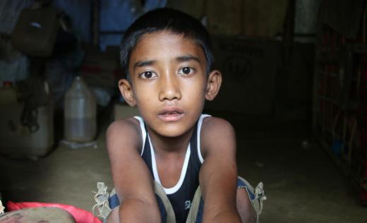 Aslam*, 8, a Rohingya refugee in his flood damaged home in Cox's Bazar