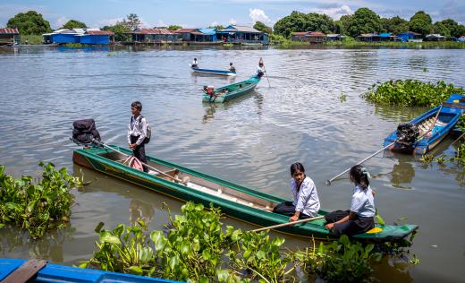 Children arrive by boat to a floating school in Cambodia
