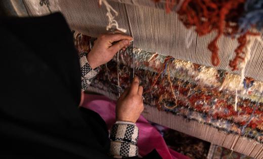 woman weaves carpets in Afghanistan