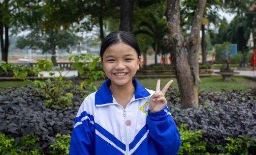a girl in Vietnam makes the 'peace sign'