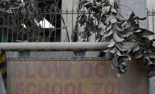 An ash-covered school sign in the town of Laurel, Batangas