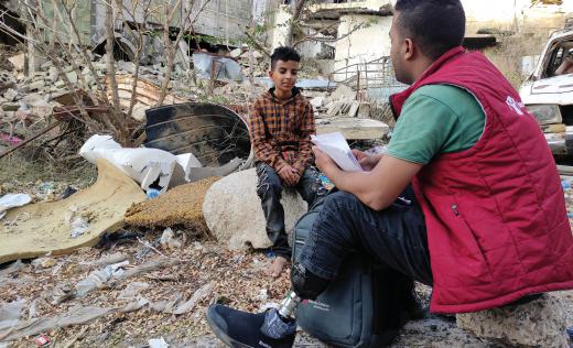 Mubarak*, Save the Children Volunteer in Taiz, Yemen with Bara'a* 11, one of the children he's assisting