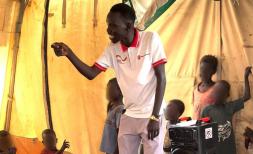 Stephen Kang singing with children in Save the Children's Child Friendly Space in Renk, South Sudan