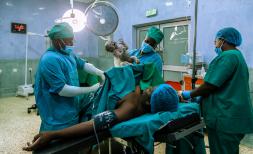 a woman has just given birth by caesarean section, surrounded by medical staff