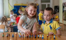 a boy and girl play with Lego blocks